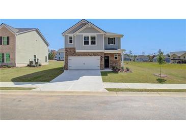 Two-story home with gray siding, brick accents, and a two-car garage at 247 Tulip Dr, Covington, GA 30016