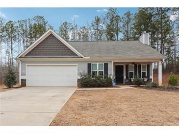 Charming one-story house with gray siding, a white garage door, and a landscaped yard at 218 Cynthia Ct, Dallas, GA 30157
