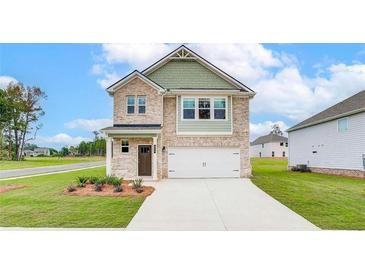 Two-story brick home with a two-car garage and landscaped front yard at 70 Barge Ln, Covington, GA 30016