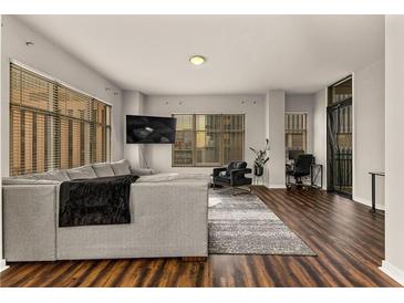 Spacious living room with hardwood floors, large windows, and modern furniture at 565 Peachtree Ne St # 804, Atlanta, GA 30308