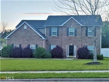 Brick two-story house with a landscaped lawn at 500 Gristmill Ln, Hampton, GA 30228