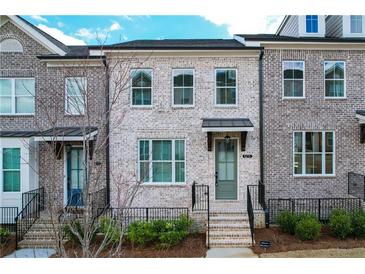 Brick townhouse exterior with a gray door and small front yard at 5215 Riden Ct, Buford, GA 30518