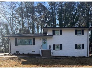 Charming two-story home featuring a white brick facade and a welcoming light blue front door at 2653 Williamsburg Dr, Decatur, GA 30034