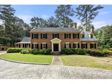 Brick colonial home with black shutters, stone driveway, and manicured lawn at 1790 Garraux Nw Rd, Atlanta, GA 30327