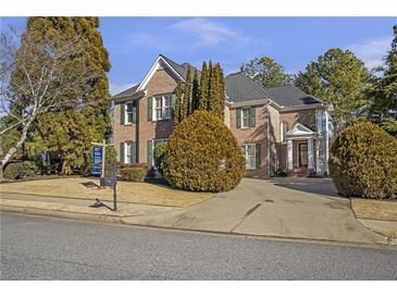 Brick two-story house with a large driveway and landscaping at 1747 Tappahannock Trl, Marietta, GA 30062