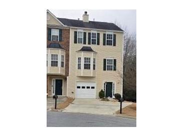 Tan three-story townhome with a white garage door and green front door at 805 Abbotts Mill Ct # 74, Duluth, GA 30097