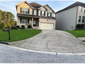 Two-story brick home with a large driveway and landscaped lawn at 3746 Wood Hollow Way, Snellville, GA 30039