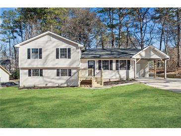 Newly renovated house with a large yard, new siding, and a covered carport at 3371 Forest Knoll Ct, Duluth, GA 30097