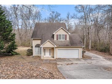 Two-story house with attached garage and driveway, nestled amongst trees at 80 Valley Dr, Stockbridge, GA 30281