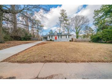 Charming one-story home with red front door, gray siding, and a well-maintained front yard at 2802 Mcafee Rd, Decatur, GA 30032