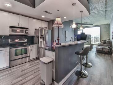 Modern kitchen features stainless steel appliances and granite countertops at 361 17Th Nw St # 1121, Atlanta, GA 30363