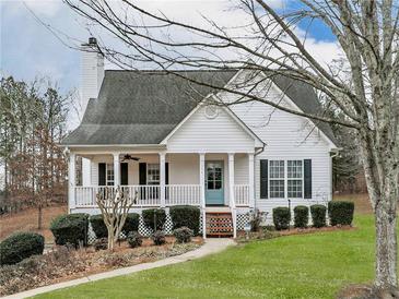 White house with front porch, landscaping, and a spacious yard at 104 Bridle Ct, Canton, GA 30114