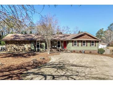 Ranch house with stone accents, wood siding, and mature trees at 665 Pine Grove Rd, Roswell, GA 30075