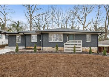 Newly renovated ranch home with gray brick exterior and modern landscaping at 1682 Valencia Rd, Decatur, GA 30032