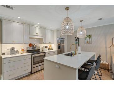 Modern kitchen with white cabinets, quartz countertops, and stainless steel appliances at 100 Verlaine Nw Pl, Atlanta, GA 30327