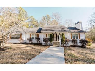 Charming white house with landscaping and a walkway at 511 Laird Rd, Hiram, GA 30141