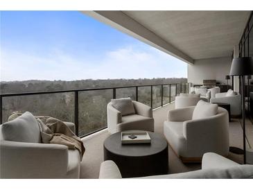 Expansive covered outdoor balcony featuring plush seating with a great view overlooking a forest landscape at 2520 Peachtree Nw Rd # 1202, Atlanta, GA 30305