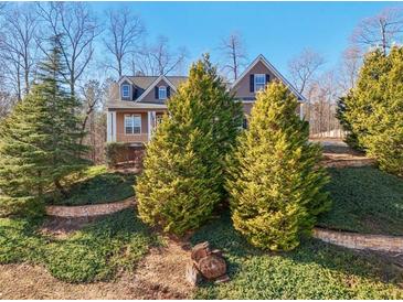 Charming exterior of home with manicured lawn, mature trees, and stone accents at 811 Somersby Dr, Dallas, GA 30157