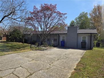 Traditional single story home with brick chimney, small front yard and long driveway at 1619 Ridgeview Nw Dr, Conyers, GA 30012