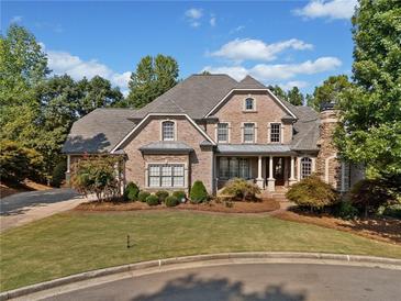 Stunning brick home featuring manicured lawn, mature trees and a classic, timeless architectural design at 149 Cedar Woods Trl, Canton, GA 30114