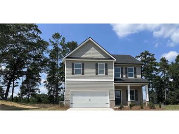 Two-story house with gray siding, a large garage, and landscaping at 45 Heyman Dr, Covington, GA 30016