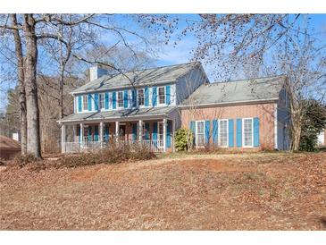 Two-story house with brick and siding, blue shutters, and a covered porch at 1491 Laurel River Trl, Lawrenceville, GA 30043