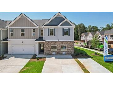 Two-story townhome with gray and beige siding, brick accents, and a two-car garage at 329 Crimson Dr, Union City, GA 30291