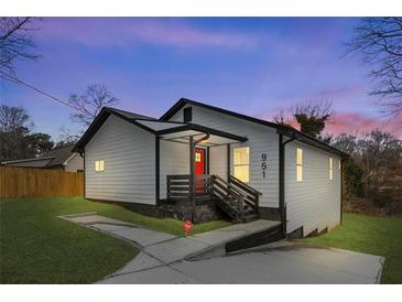 White house with red door, black accents, and a landscaped yard at 951 Reed Ave, Atlanta, GA 30344