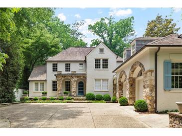 Stunning two-story home with a stone archway and elegant landscaping, nestled among lush greenery at 2522 Habersham Nw Rd, Atlanta, GA 30305