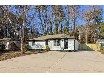 Newly renovated single-story home with a white brick facade and a spacious driveway at 4378 Glenwood Pkwy, Decatur, GA 30032