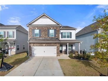 Two-story brick home with a large front yard and driveway at 1566 Ribbon Mill Sw Ln, Mableton, GA 30126