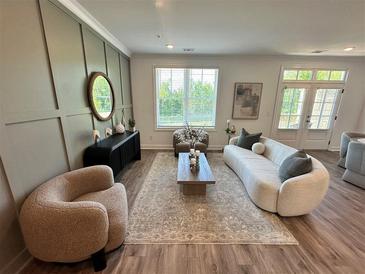Bright living room features a curved sofa, modern decor, and neutral color palette, creating an inviting atmosphere at 534 Sawnee Village Blvd # D65, Cumming, GA 30040
