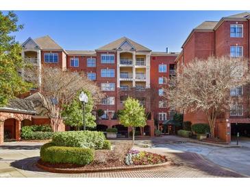 Exterior of a multi-story brick building with manicured landscaping and a circular driveway at 211 Colonial Homes Nw Dr # 1105, Atlanta, GA 30309