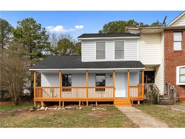 Charming townhouse with painted brick and a cozy front porch, perfect for relaxing outdoors at 8168 Canyon Forge Dr, Riverdale, GA 30274