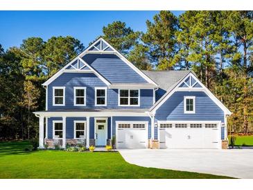 Two-story blue house with white accents, two-car garage, and a well-manicured lawn at 105 Arborvale Dr, Fayetteville, GA 30214