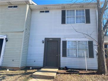 Two-story townhouse with neutral siding and a brown door at 1753 Ridge Se Ct, Conyers, GA 30013