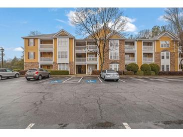 View of the apartment building exterior showing balconies, parking, and stone accents at 533 Bentley Pl, Tucker, GA 30084