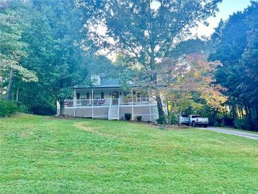 House exterior featuring a wraparound porch and landscaped yard at 414 Deering Dr, Douglasville, GA 30134