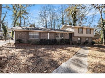 Brick ranch house with a two-car attached garage and a large backyard at 1980 Campfire Dr, Riverdale, GA 30296