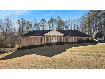 Brick ranch home with a large yard and mature trees at 157 Timberlost Trl, Suwanee, GA 30024