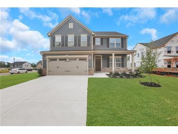 Two story home with gray siding, three car garage, and landscaped lawn at 1601 Fuma Leaf Way, Mcdonough, GA 30253