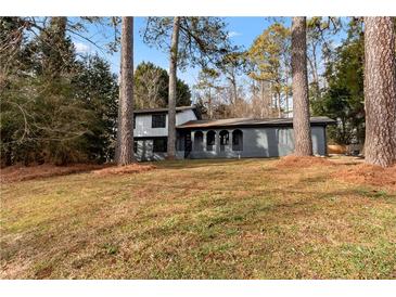 Gray exterior house with a white trim, and a large yard at 4399 Plantation Ln, Norcross, GA 30093