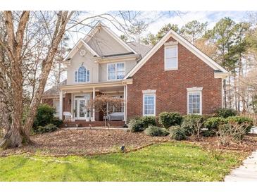 Charming two-story home featuring brick and stucco exterior with a welcoming front porch and well-maintained landscaping at 8240 Knollbrook Ln, Mcdonough, GA 30253