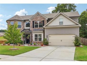 Two-story brick home with a large yard and attached garage at 3126 Cove View Court, Dacula, GA 30019