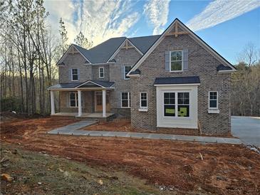 Brick two-story house with a large front porch and driveway at 7449 Waterview Cv, Douglasville, GA 30135