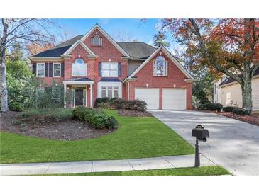 Brick two-story house with attached garage and landscaped lawn at 1215 Wynridge Xing, Alpharetta, GA 30005