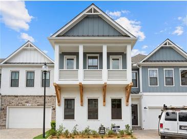 Two-story craftsman style home with gray and white exterior, two-car garage, and landscaped front yard at 89 Batten Board Way, Woodstock, GA 30189