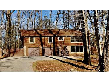 Two-story house with attached two-car garage and wooded backdrop at 2395 River Run Dr, Douglasville, GA 30135