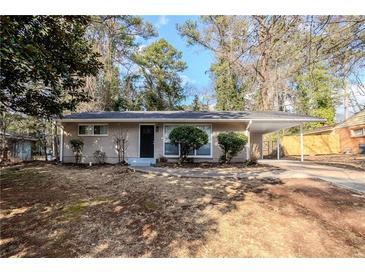 Charming brick home featuring mature landscaping and a convenient carport at 3418 Longleaf Dr, Decatur, GA 30032