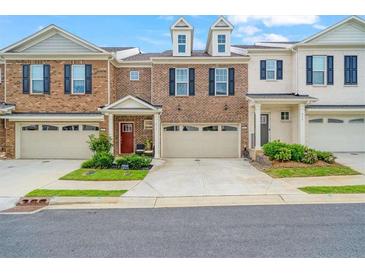 Brick townhome with 2-car garage and landscaped front yard at 413 Delancy Dr, Woodstock, GA 30189